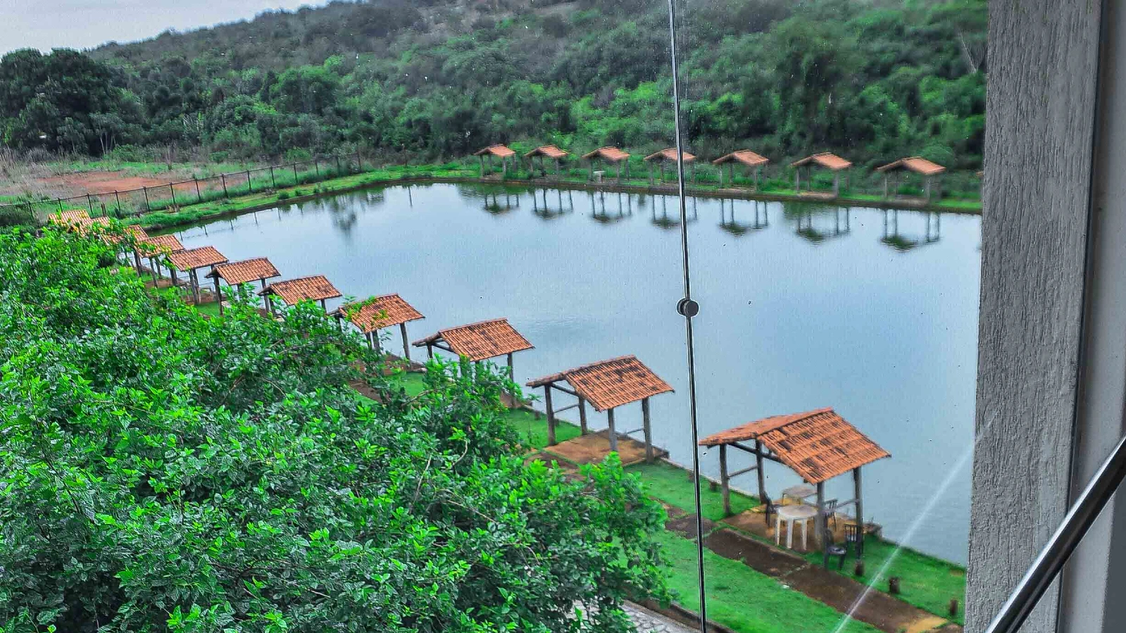 Fileira de quiosques de pesca cobertos à beira do lago do Clube Pescar, vista de cima